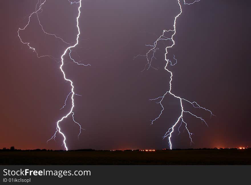 Two bolts of lightning light up the night sky. Two bolts of lightning light up the night sky.