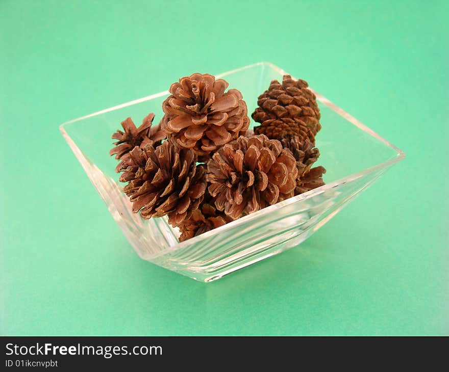 Pine cones in glass dish isolcated over solid background