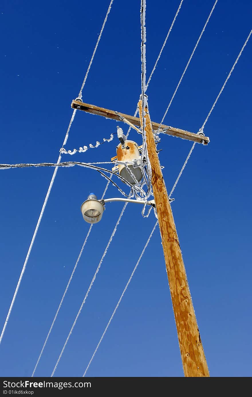 Telephone pole in winter convered in frost and snow