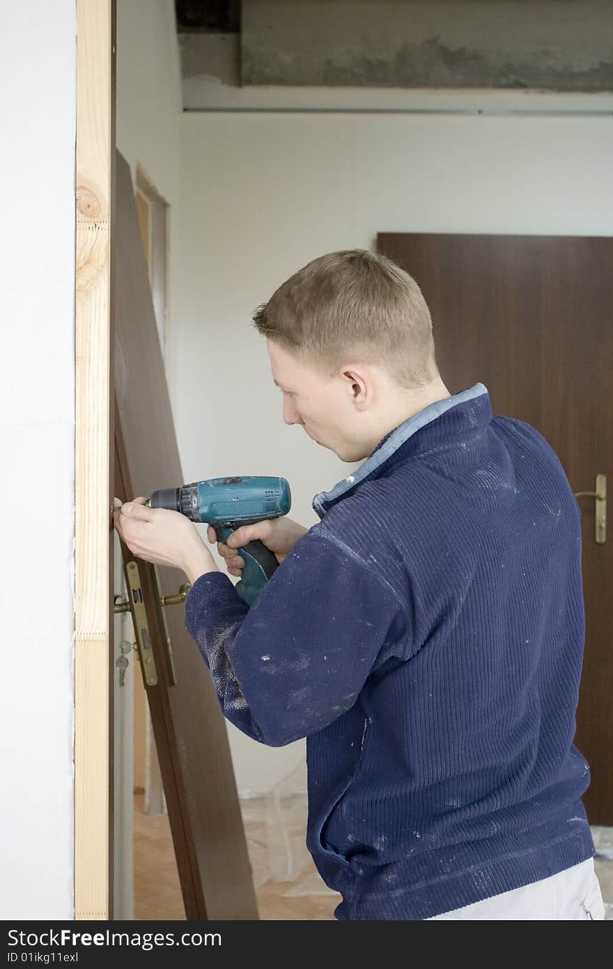 construction joiner installs door. insertion screw