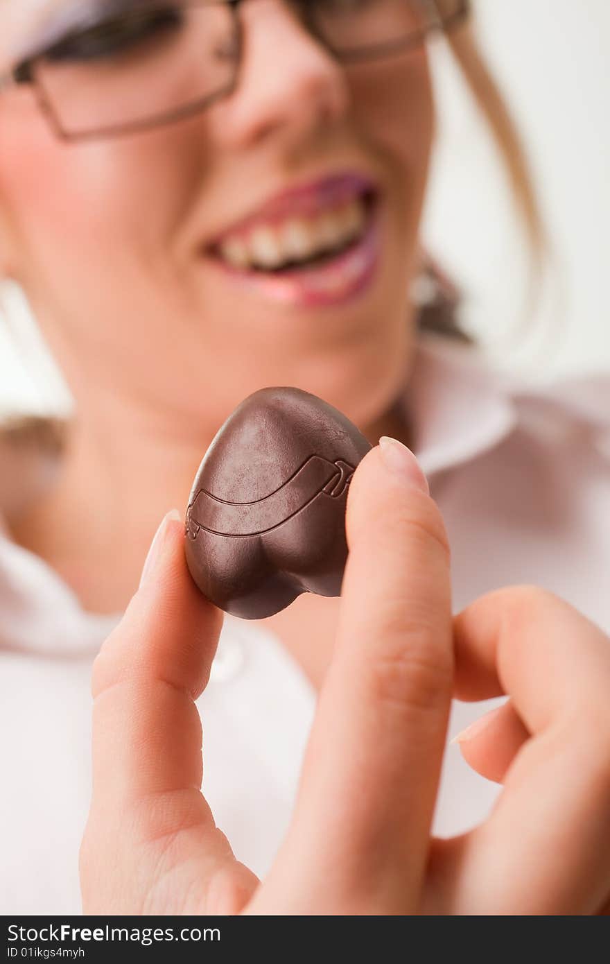 Pretty woman holding chocolate heart shaped candy