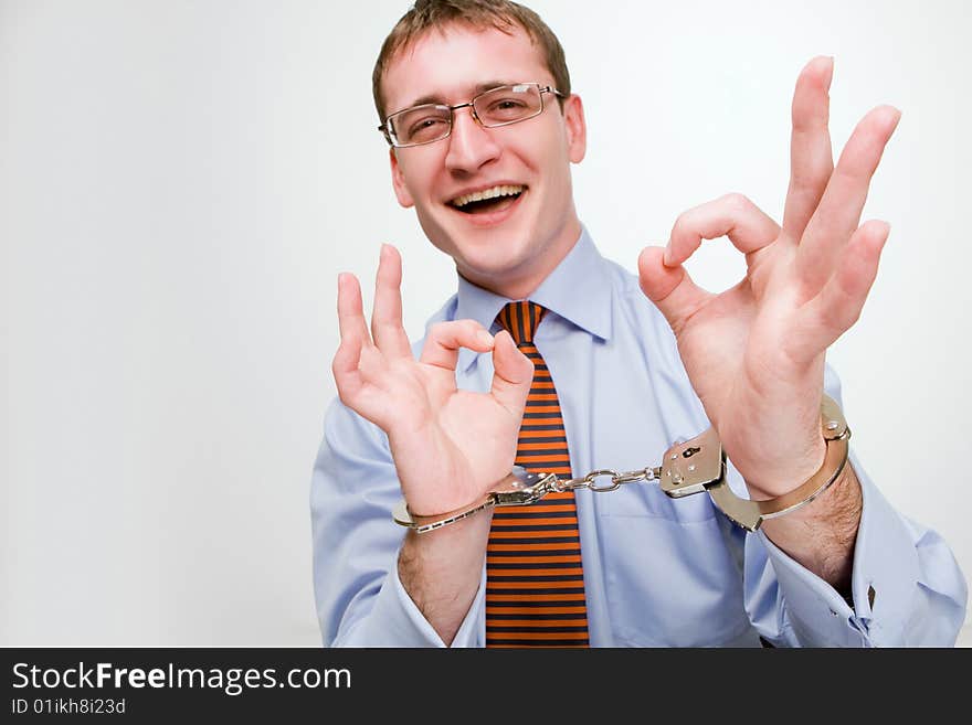 Handsome young businessman bound to laptop with handcuffs. Handsome young businessman bound to laptop with handcuffs