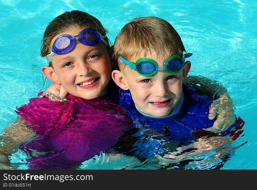 Brother and sister a pool with goggles. Brother and sister a pool with goggles