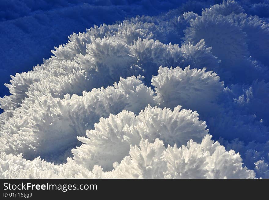 Fine ice crystals on snow mounds formed by hoar frost