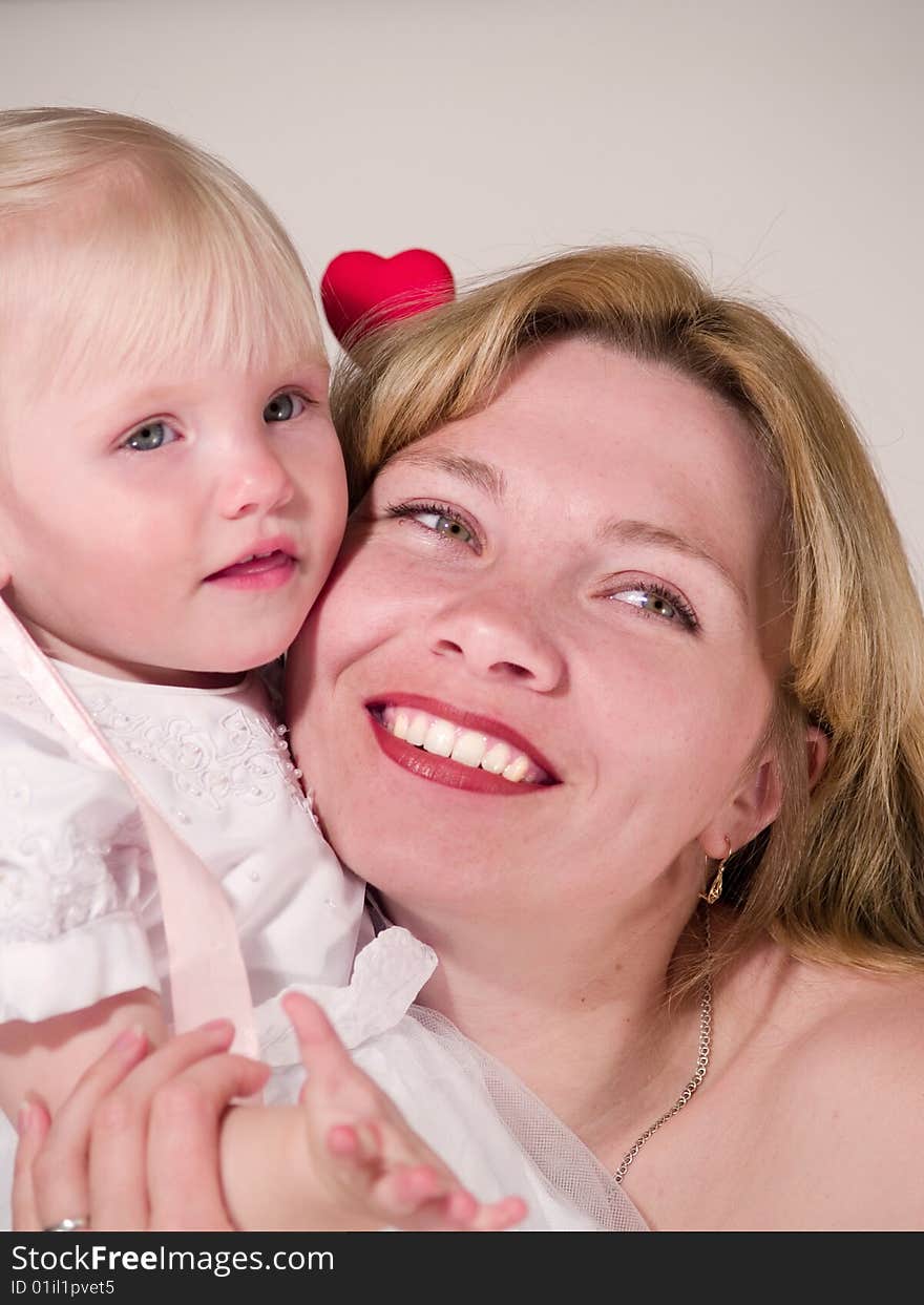 Beauty woman embraces blond daughter. Beauty woman embraces blond daughter