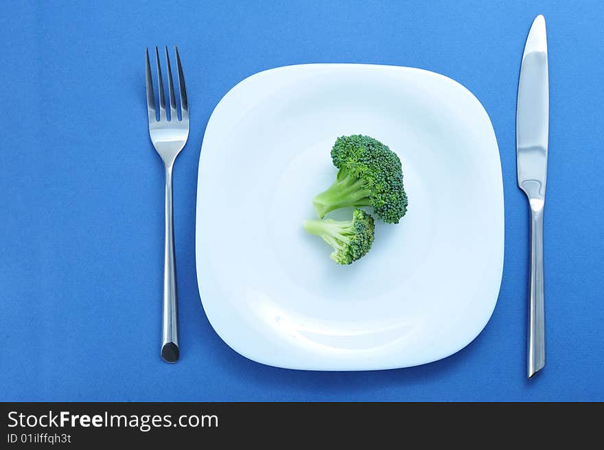 Broccoli in white plate on blue background