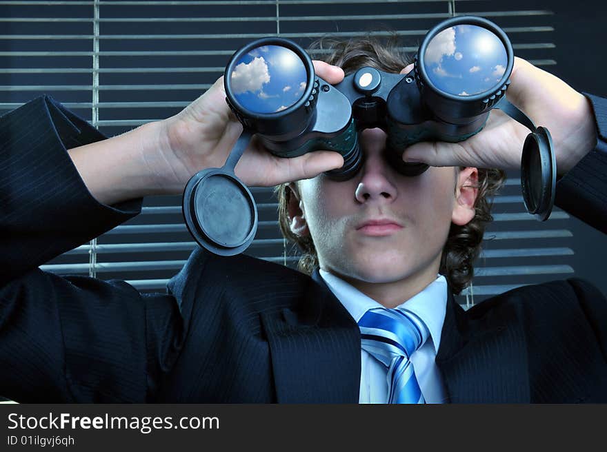 Businessman looking through binoculars, sky reflection on lens. Businessman looking through binoculars, sky reflection on lens