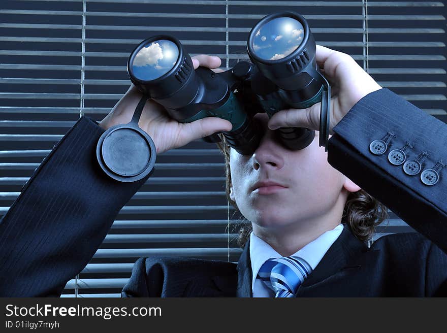 Businessman looking through binoculars, sky reflection on lens. Businessman looking through binoculars, sky reflection on lens