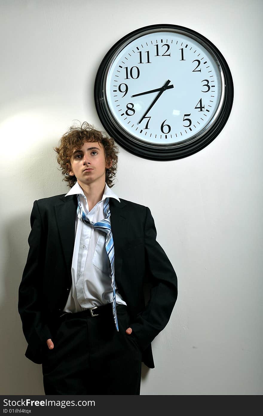 Young businessman looking at clock, deadline concept. Young businessman looking at clock, deadline concept