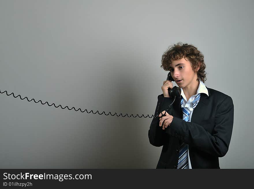 Young business man talking on old phone. Young business man talking on old phone