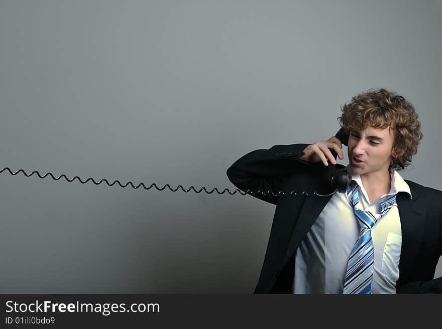 Young business man talking on old phone. Young business man talking on old phone