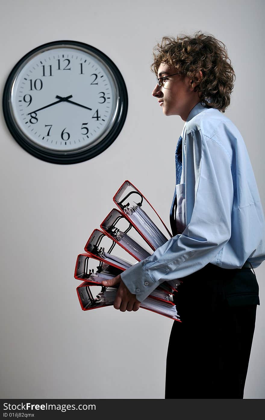 Young businessman holding stack of folders in office, deadline concept. Young businessman holding stack of folders in office, deadline concept