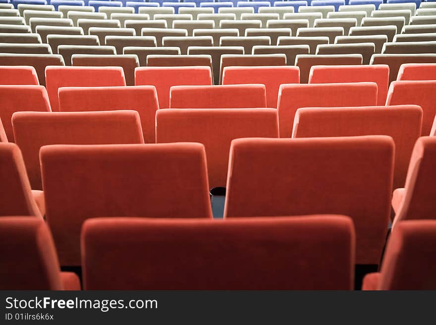 Empty new cinema auditorium with rows of blue, gray and red chairs. Empty new cinema auditorium with rows of blue, gray and red chairs.