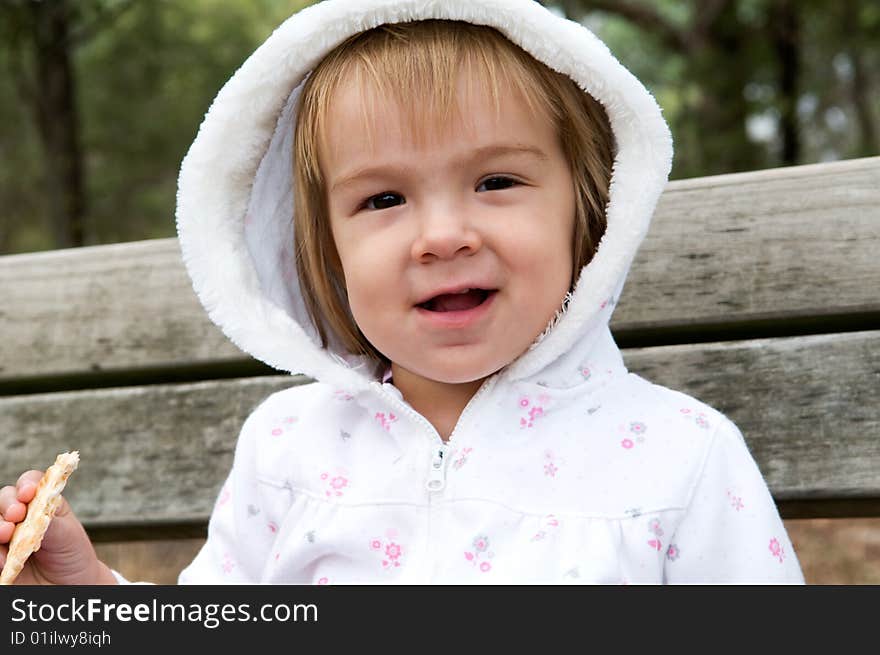 A young girl having a tea-break on a bench in a public park. A young girl having a tea-break on a bench in a public park