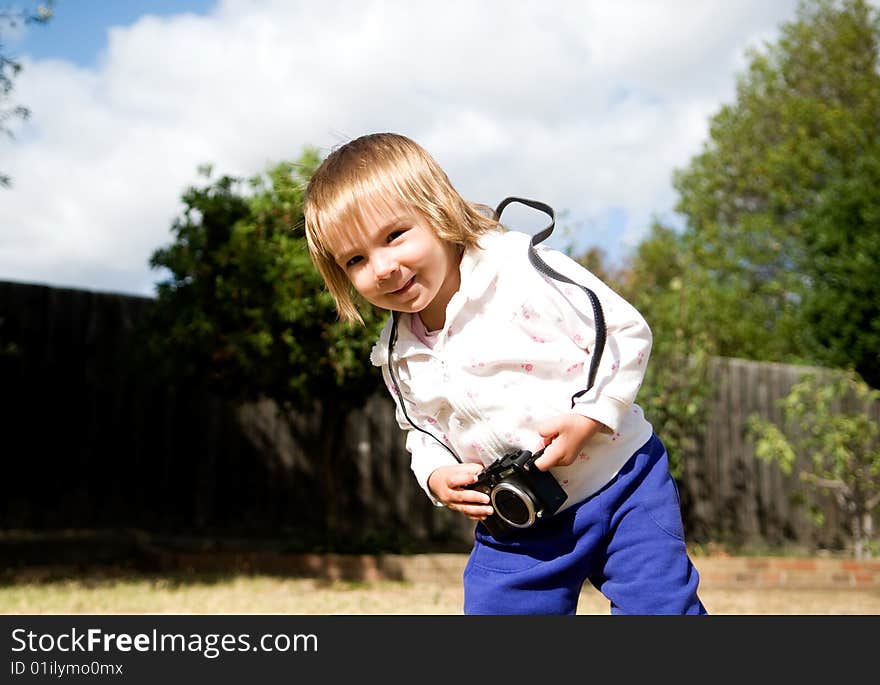 A young girl playing with a compact digital camera. A young girl playing with a compact digital camera