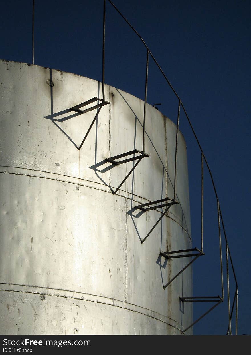 Cylindrical fuel storage tanks with staircase running along the side