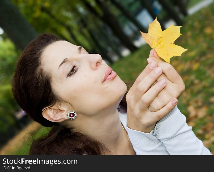 Pretty girl blowing on leaf