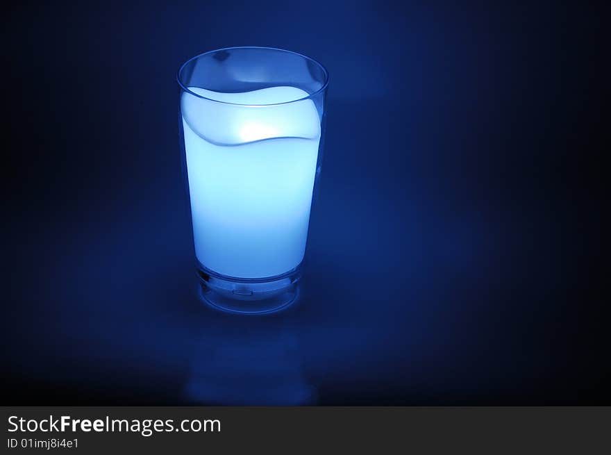 Cup filled with milk mapping under the lights in the background