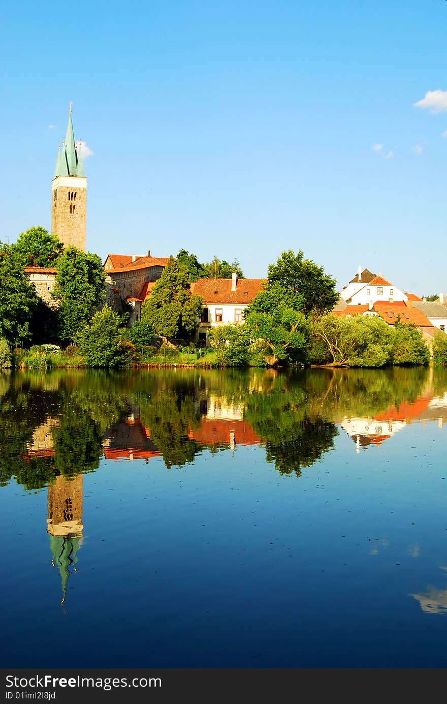 Tower and Houses reflected in the lake surrounding the city of Telc, Southern Moravia, Czech Republic. Tower and Houses reflected in the lake surrounding the city of Telc, Southern Moravia, Czech Republic.