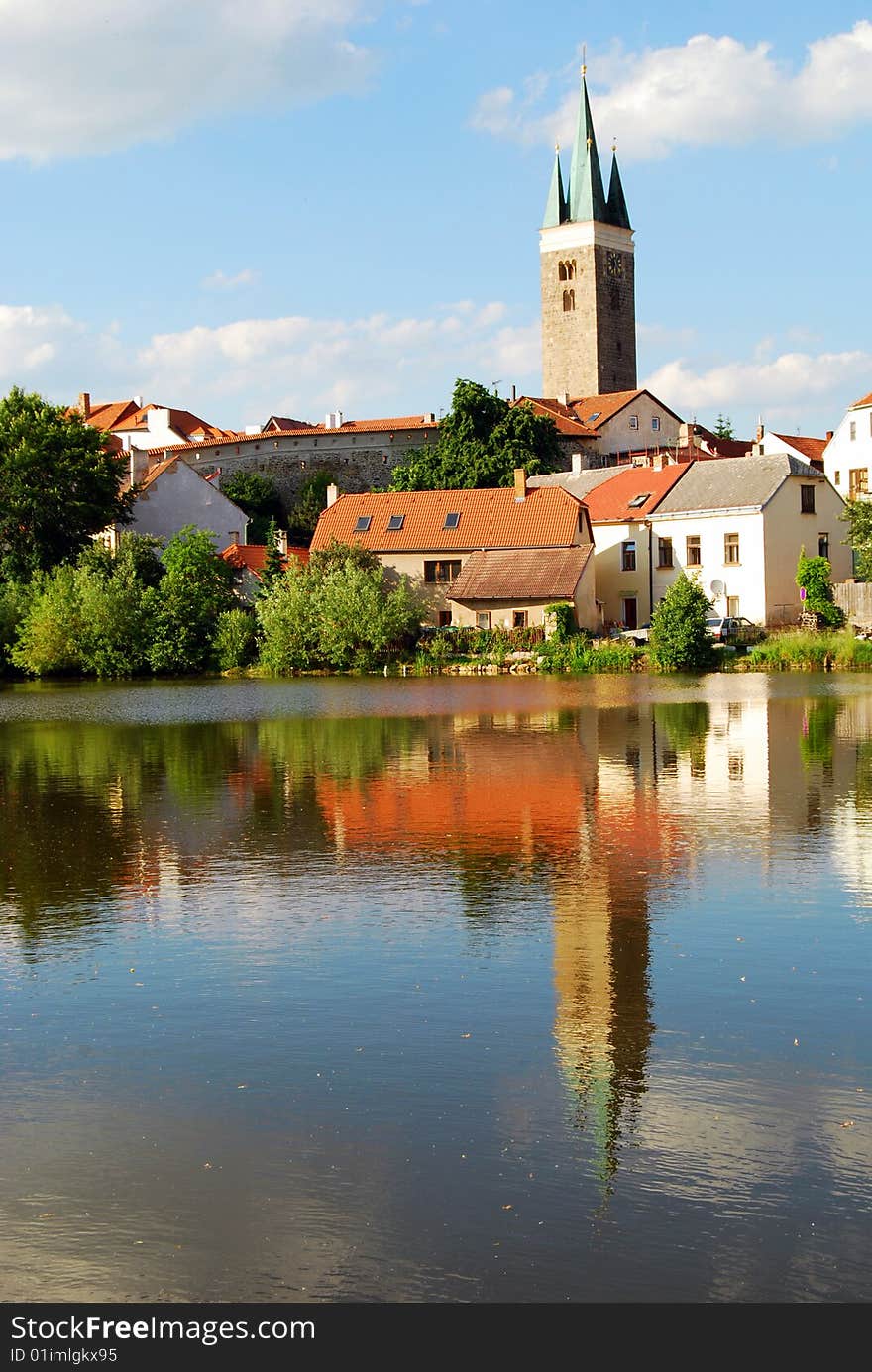 Tower and Houses with Lake Reflection