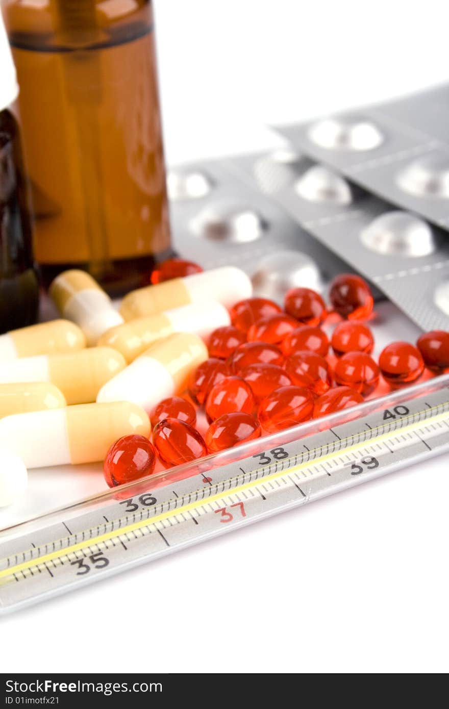 Thermometer and different pills closeup on white background. Thermometer and different pills closeup on white background