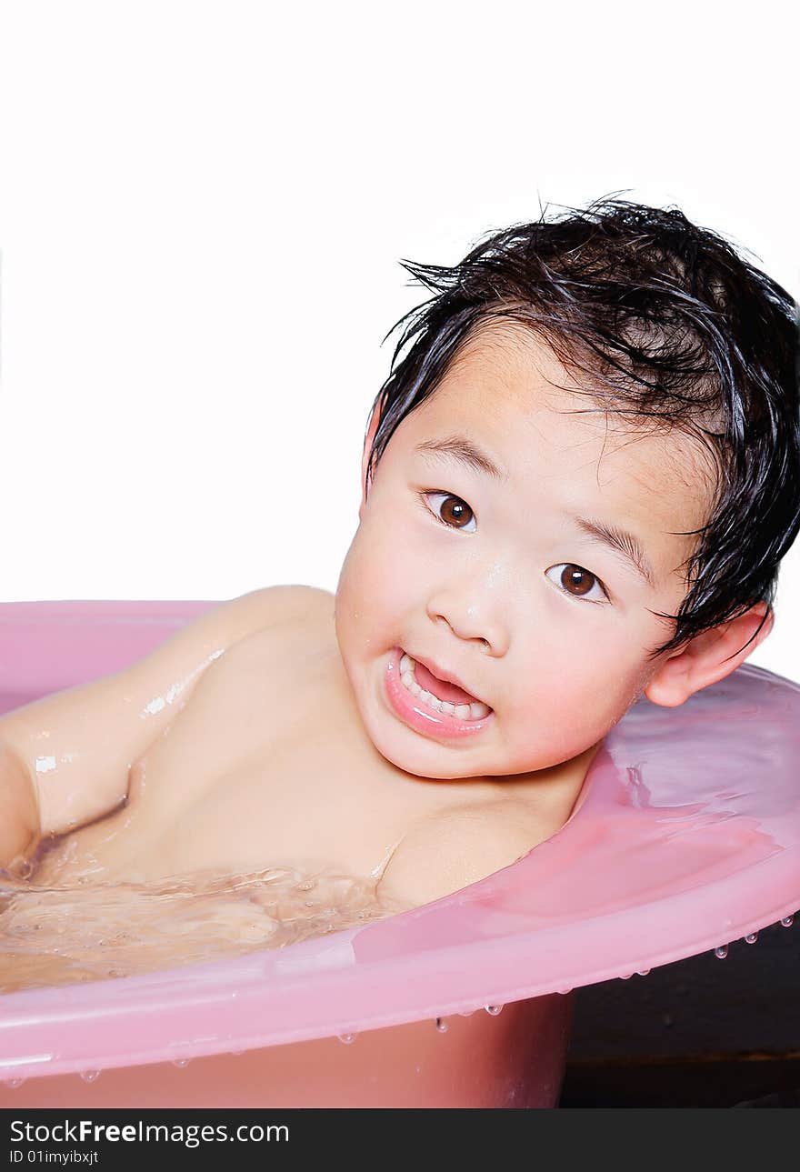 A picture of a little chinese boy taking bath and playing with water happily. A picture of a little chinese boy taking bath and playing with water happily