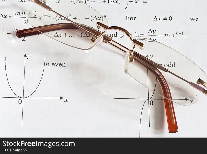 A pair of glasses on a maths teach book. A pair of glasses on a maths teach book