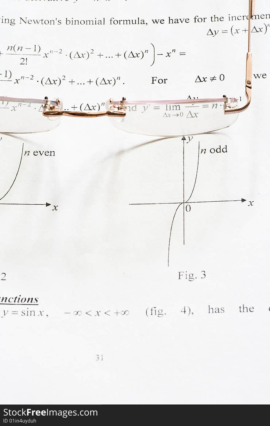 A pair of glasses on a maths teach book. A pair of glasses on a maths teach book