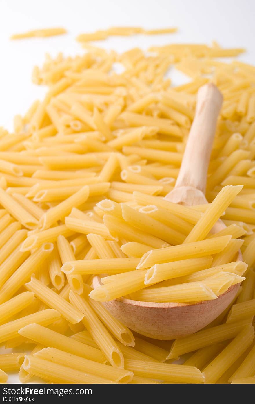 Raw italian macaroni and wooden spoon