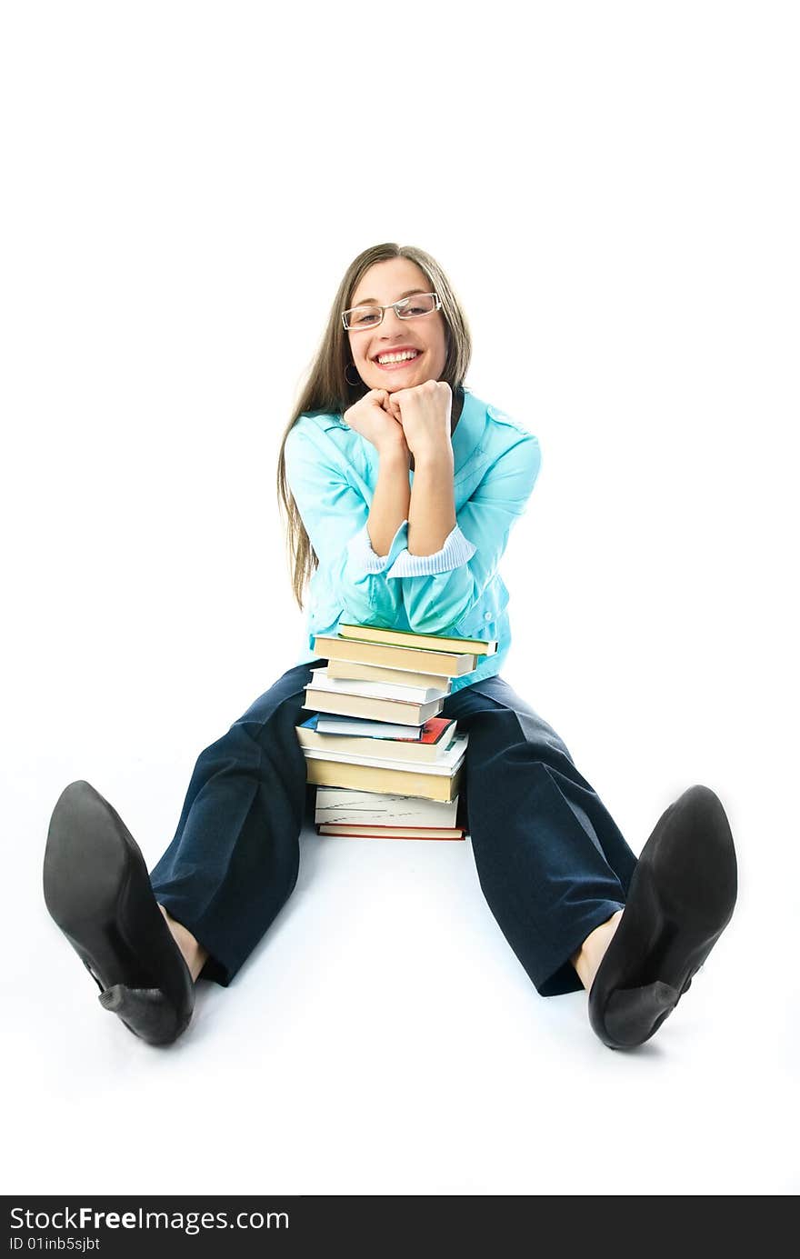 Young cheerful student sitting on the floor with a lot of books and smiling. Young cheerful student sitting on the floor with a lot of books and smiling