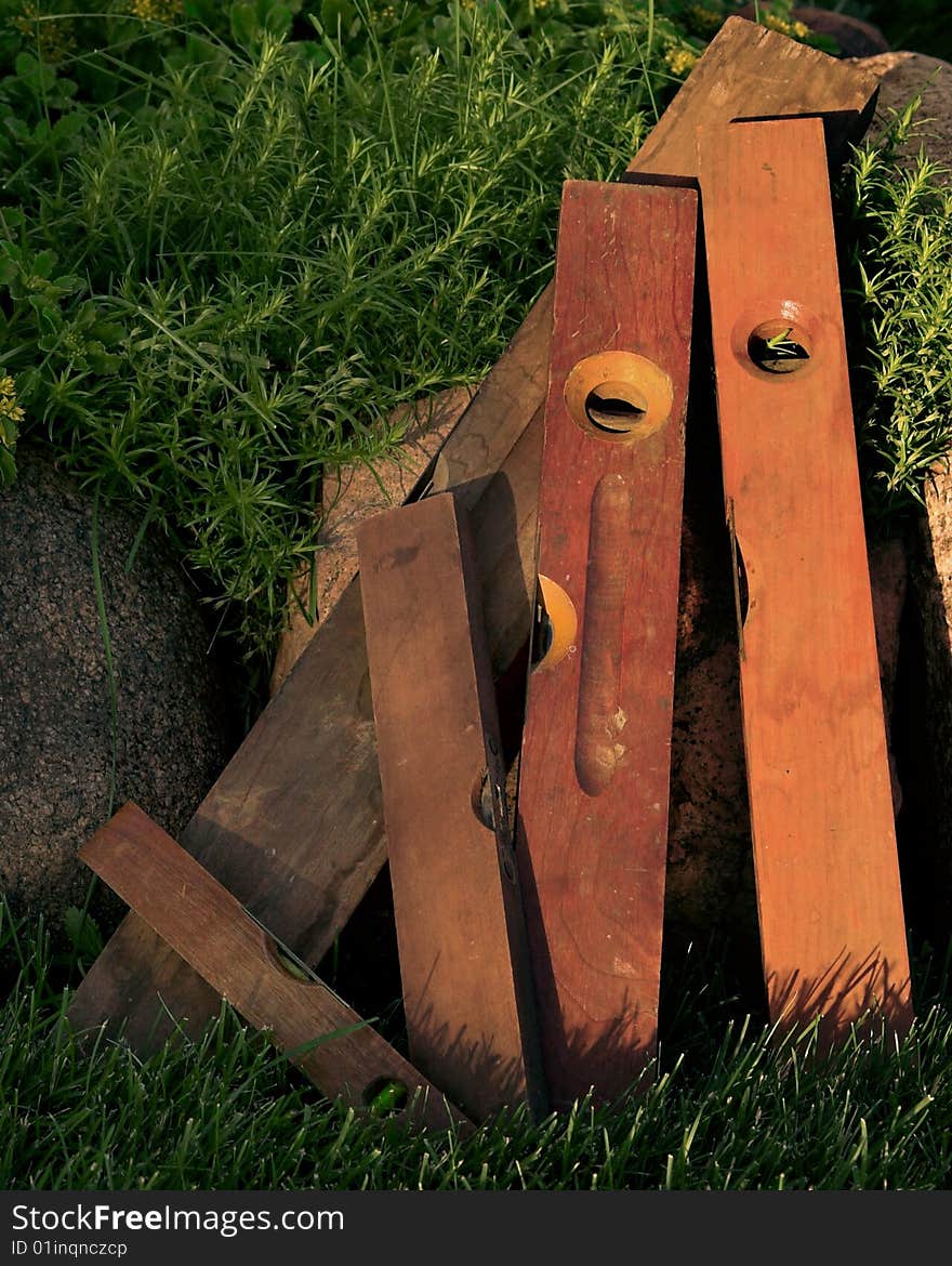 Old Vintage levels, leaning on rocks. in the grass