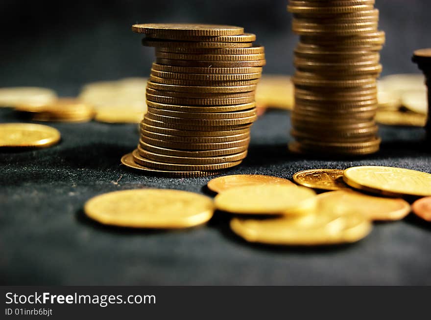 A pile of golden coins on dark background