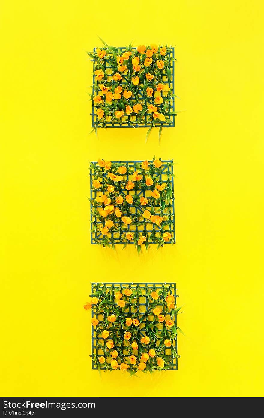 Three square flowers decoration at yellow wall