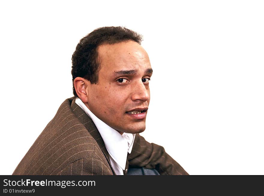 Serious over the shoulder look of african american male wearing dress shirt and suit coat against white background