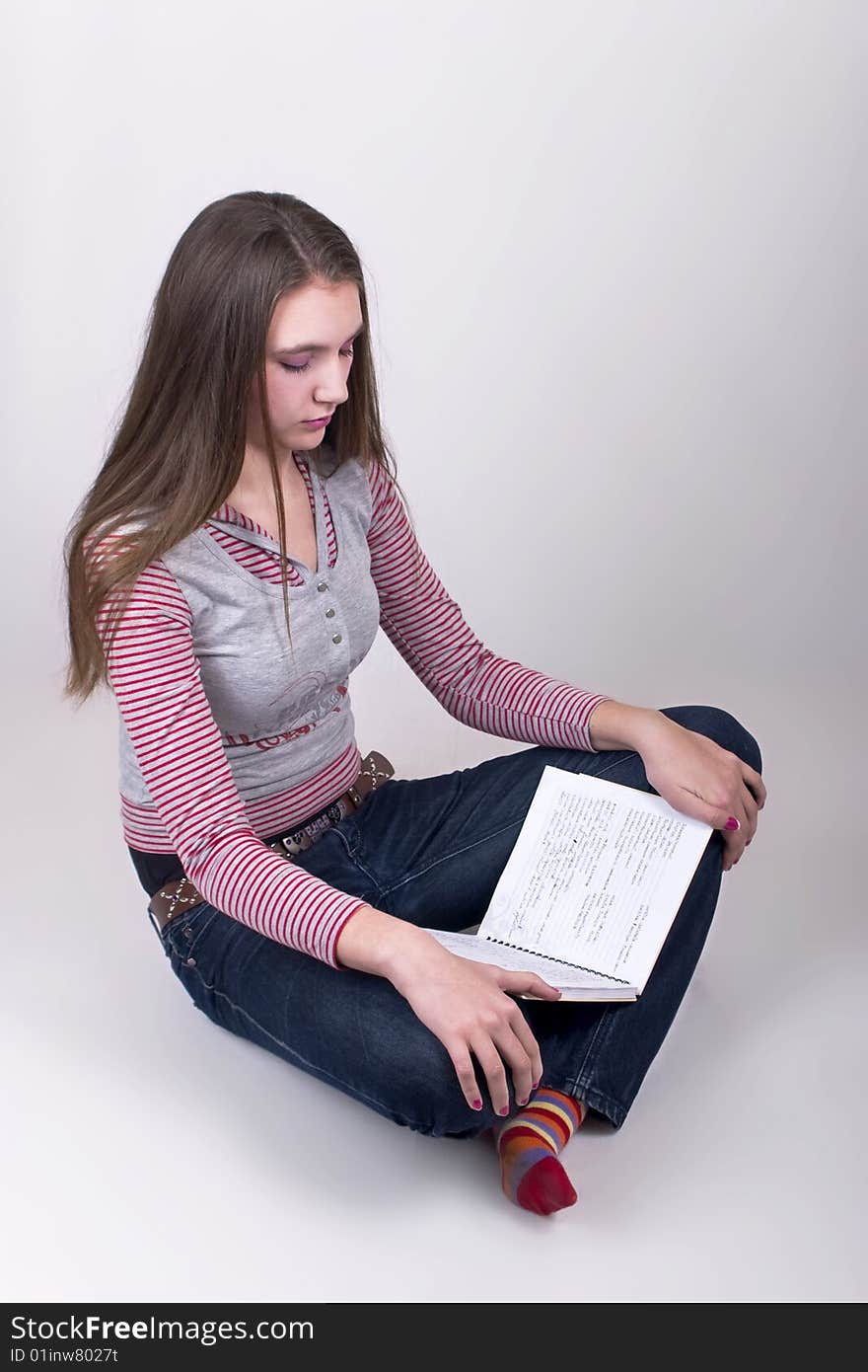 Girl Sitting On The Floor And Reading