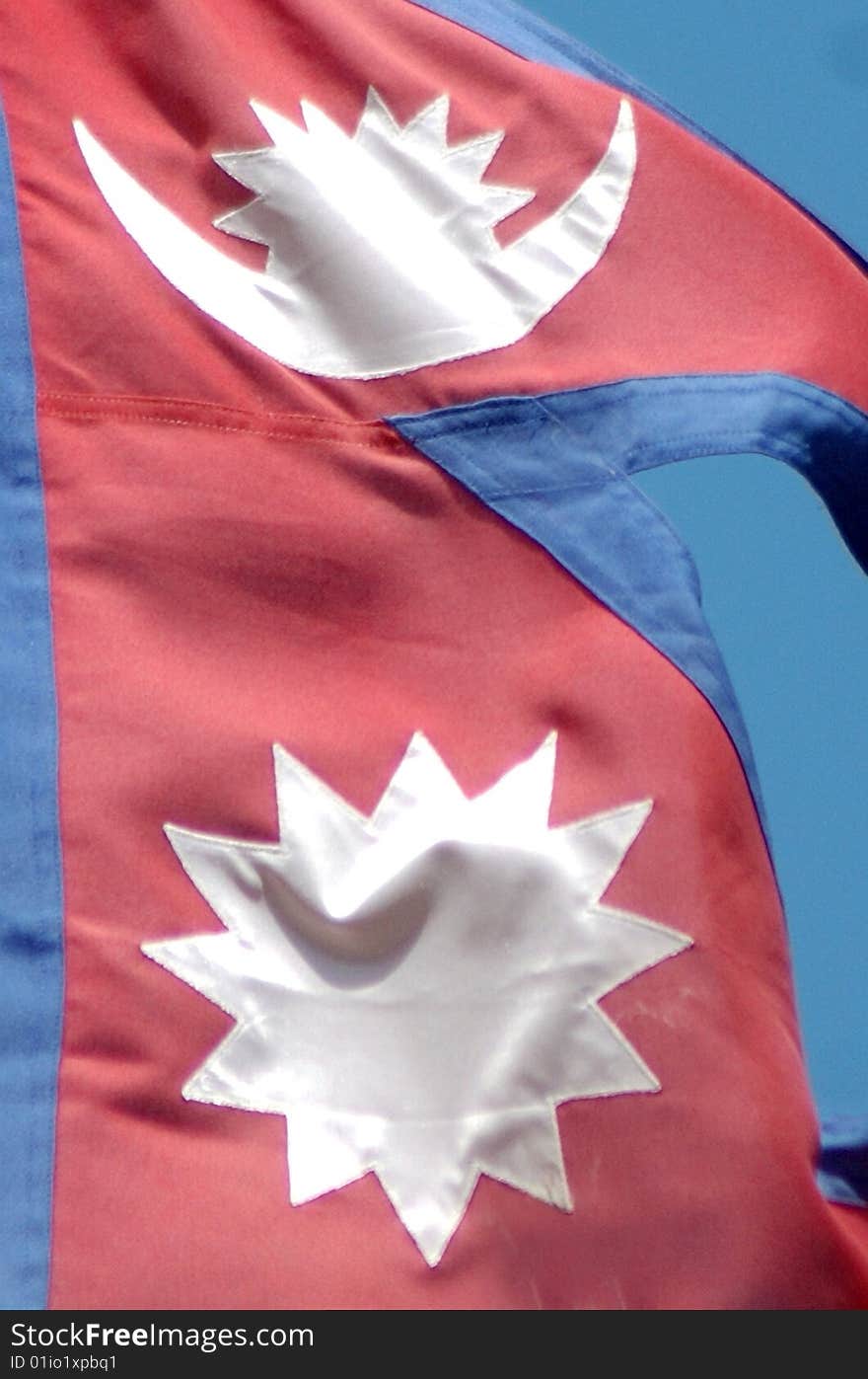 The flag of Nepal against blue sky. The flag of Nepal against blue sky