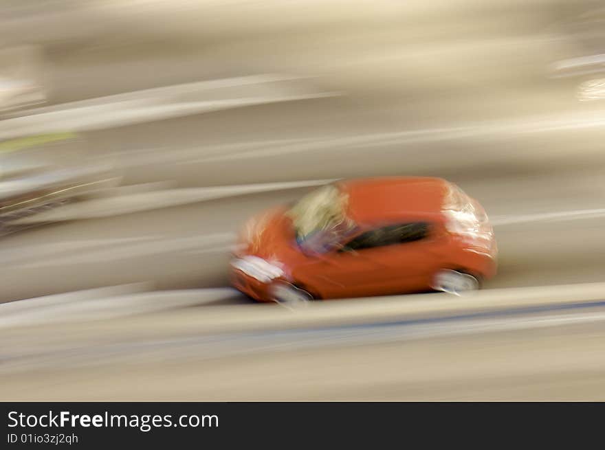 Red car in motion in Madrid street; Spain