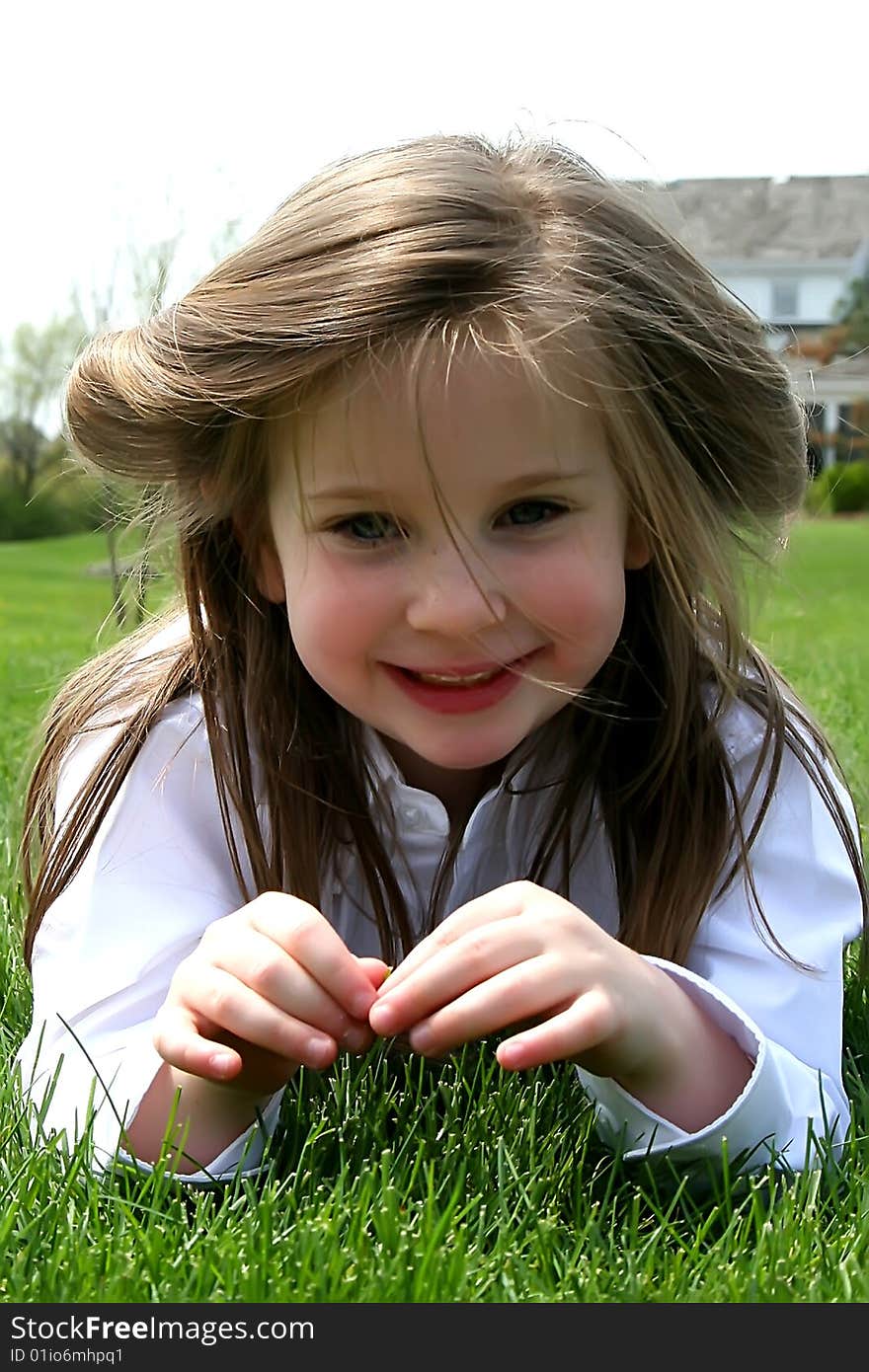 A little girl plays in the grass. A little girl plays in the grass