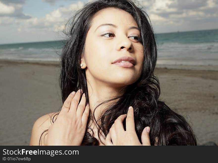 Young woman glancing away while touching her hair. Young woman glancing away while touching her hair