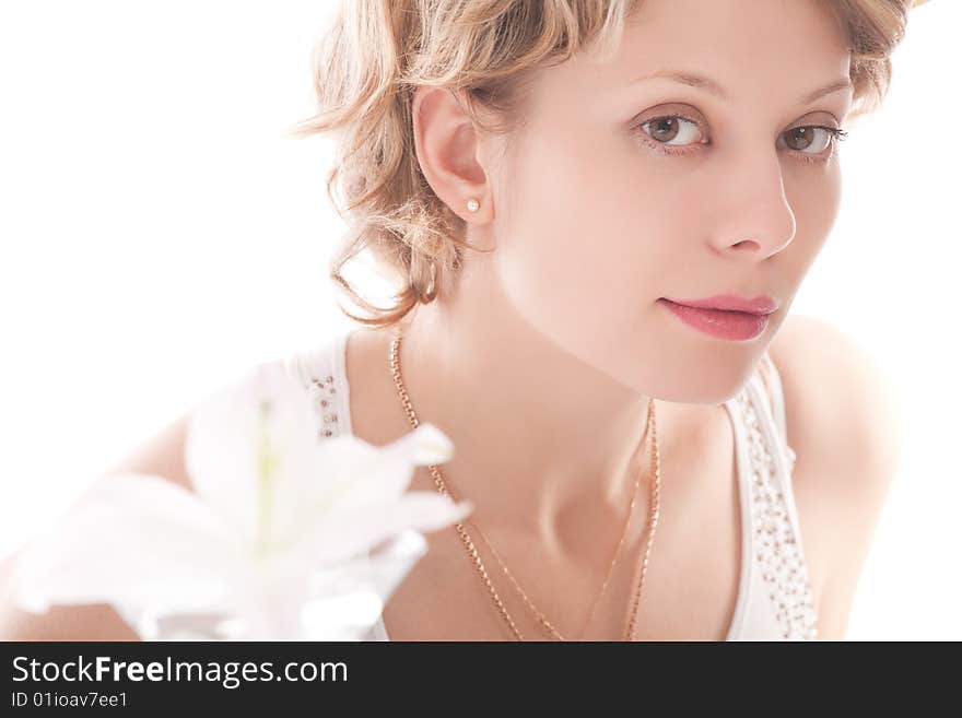 Portrait of attractive blond girl with white lily over white background