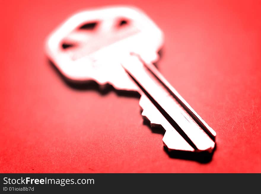 Key lying on flat red surface. Key lying on flat red surface