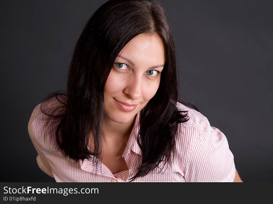 Smiling woman closeup portrait over gray in studio. Smiling woman closeup portrait over gray in studio