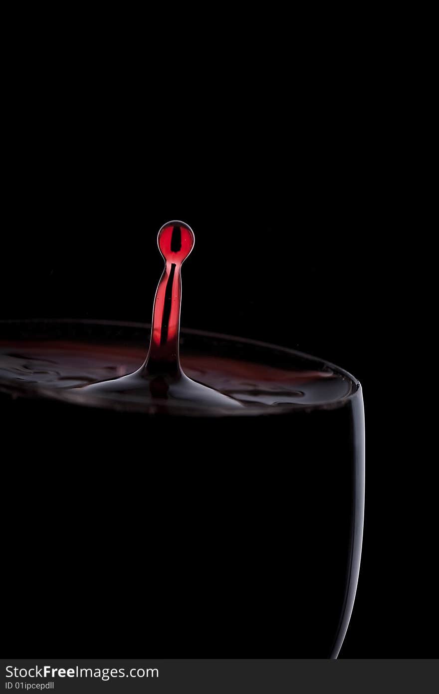 A Drop Of Red Wine Falls Into The Glass