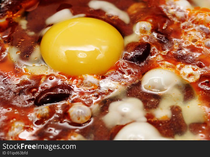 Eggs and red beans in the chili sauce fry on the skillet. Narrow depth of field. Eggs and red beans in the chili sauce fry on the skillet. Narrow depth of field.