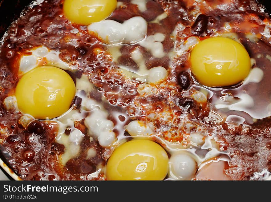 Eggs and red beans in the chili sauce fry on the skillet. Narrow depth of field. Eggs and red beans in the chili sauce fry on the skillet. Narrow depth of field.