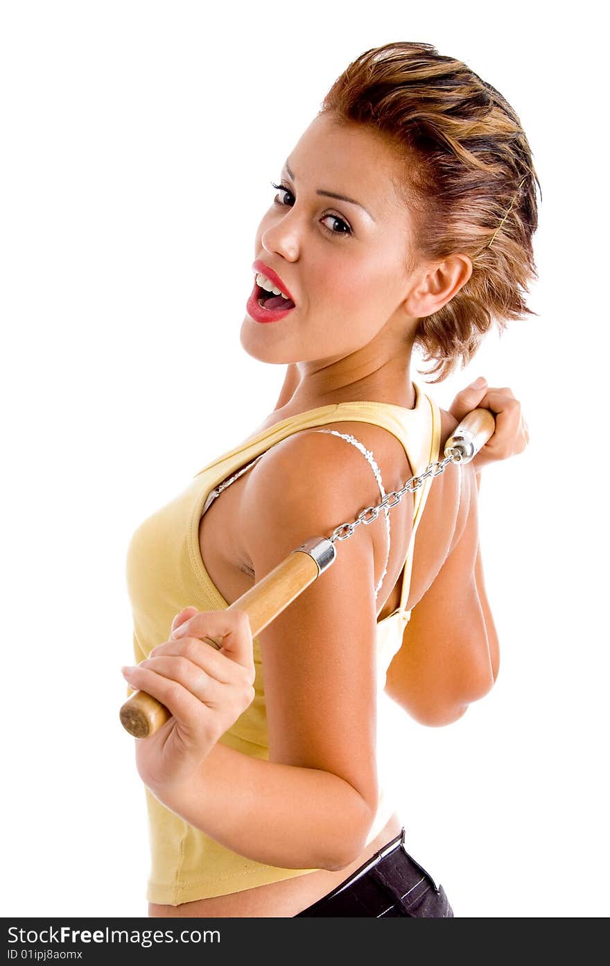 Side view of young woman with nunchaku on an isolated white background