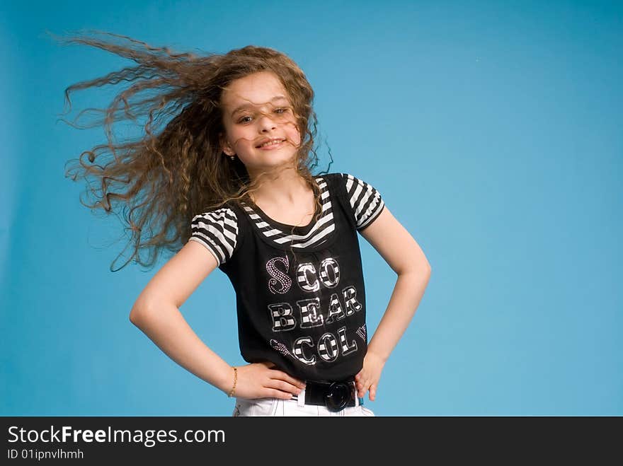 Young sweet girl showing her healthy beautiful long brown curly hair in motion created by wind. Young sweet girl showing her healthy beautiful long brown curly hair in motion created by wind