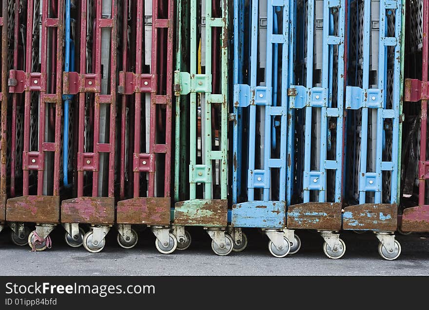 A line of old trolleys. They are weathered but they still have attractive colours. Could be used for transferring or transporting stuff.