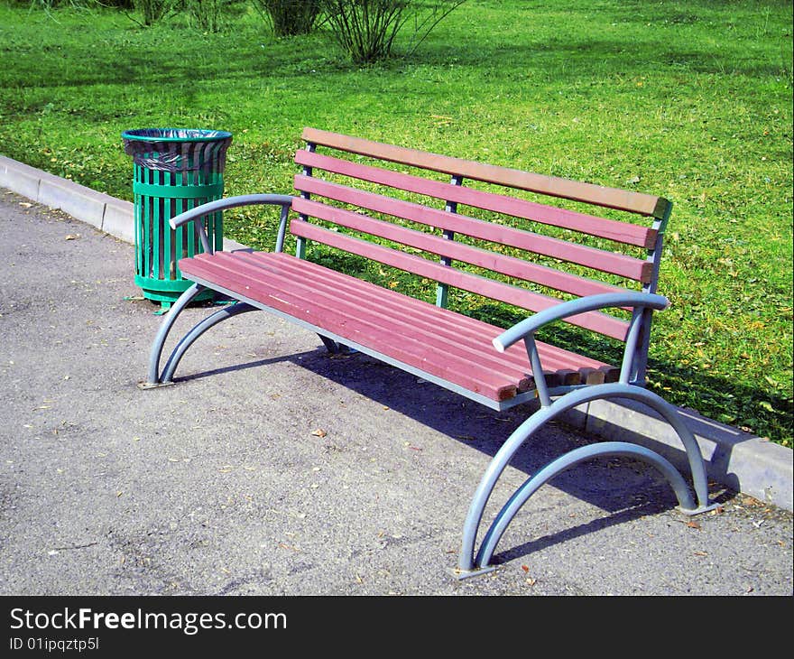 Bench in a park on a background a spring grass