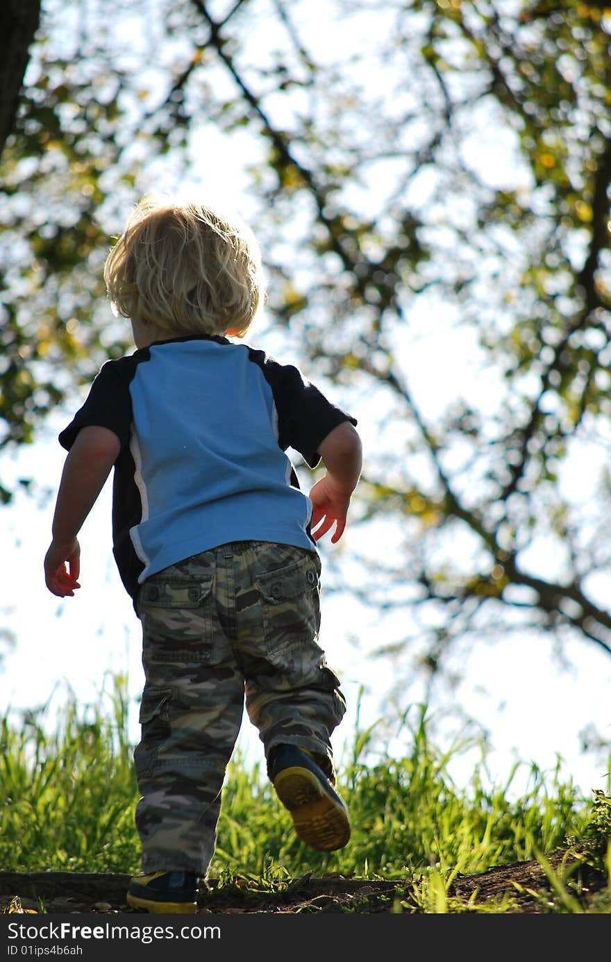 Small Boy Running Up A Hill